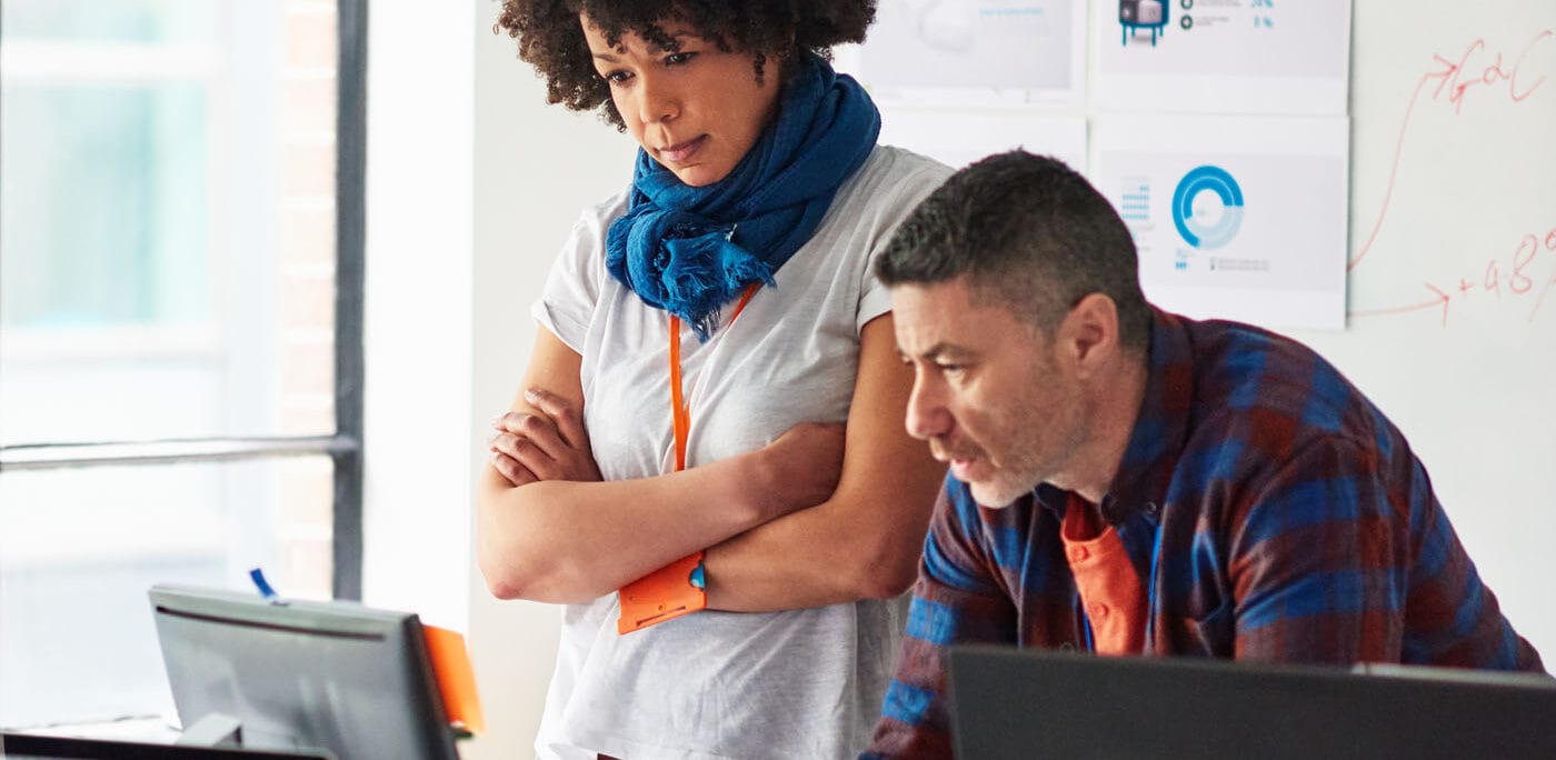 Coworkers conferring by a computer monitor